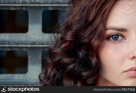 Half of face of sad depressed girl in front of metal grid, teenager prisoner or abuse victim concept. Half of face of sad depressed girl in front of metal grid, teenager prisoner