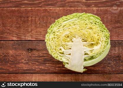 half of green savoy cabbage on red barn wood table with a copy space