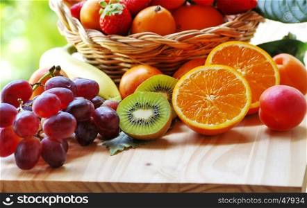 half orange, sliced kiwi, other fruits in the basket