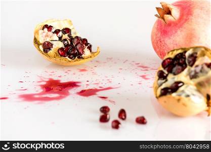 Half pomegranate and seeds on white background. Half pomegranate and seeds