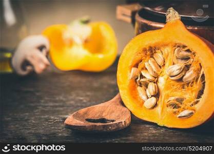 Half pumpkin with seeds and cooking spoon, front view, close up