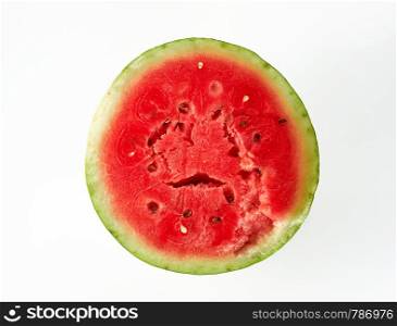 half ripe red watermelon with brown seeds on a white background, top view