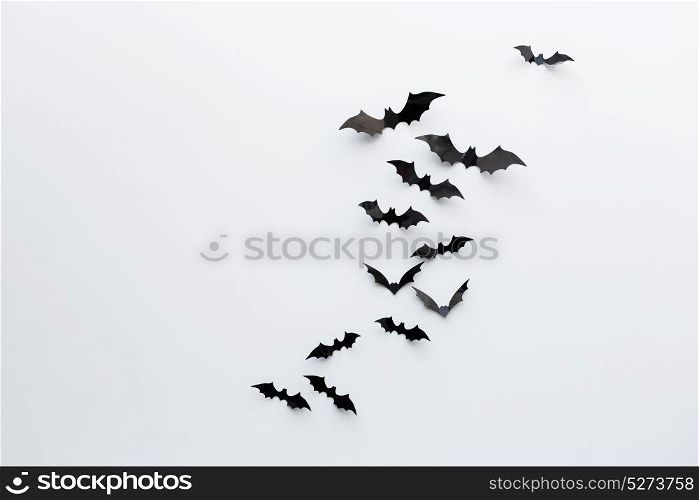 halloween and decoration concept - black paper bats flying over white background. black paper bats over white background