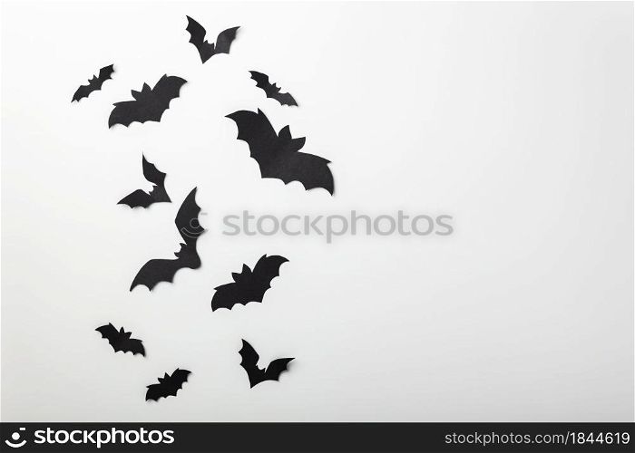 halloween and decoration concept - black paper bats flying over white background, copy space. halloween and decoration concept - black paper bats flying over white background