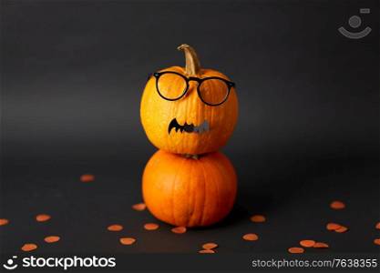 halloween and holiday concept - halloween pumpkins with glasses and bat. halloween pumpkins with glasses and bat