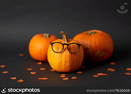 halloween and holiday concept - halloween pumpkins with glasses. halloween pumpkins with glasses
