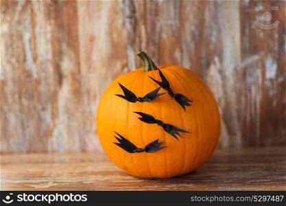 halloween and holidays concept - pumpkins with bats or party decorations. pumpkins with bats or halloween party decorations