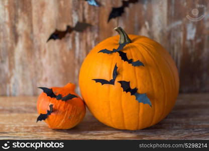 halloween and holidays concept - pumpkins with bats or party decorations. pumpkins with bats or halloween party decorations