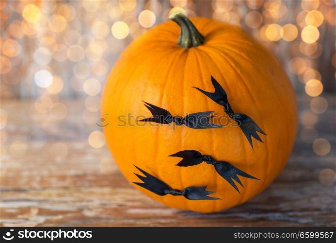 halloween and holidays concept - pumpkins with bats or party decorations. pumpkins with bats or halloween party decorations
