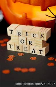 halloween, autumn holidays and decorations concept - wooden toy blocks with trick or treat letters on table. toy blocks with trick or treat words on halloween