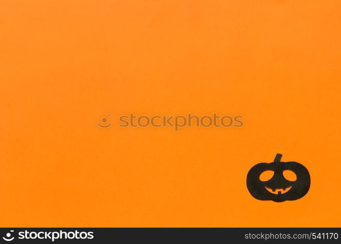 Halloween background. Black paper pumpkin on orange background Happy halloween concept, space for text. Top view. Mockup, Layout Flat lay. Halloween background. Black paper pumpkin on orange background