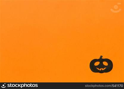 Halloween background. Black paper pumpkin on orange background Happy halloween concept, space for text. Top view. Mockup, Layout Flat lay. Halloween background. Black paper pumpkin on orange background