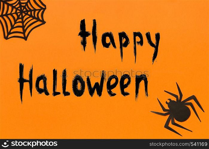 Halloween background. Black paper spider, spiderweb and text Happy Halloween on orange background Concept, space for text Top view Mockup, Layout Flat lay. Halloween background. Text Happy Halloween Black paper spider and spiderweb on orange background