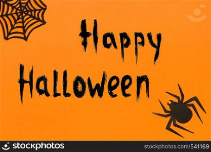 Halloween background. Black paper spider, spiderweb and text Happy Halloween on orange background Concept, space for text Top view Mockup, Layout Flat lay. Halloween background. Text Happy Halloween Black paper spider and spiderweb on orange background
