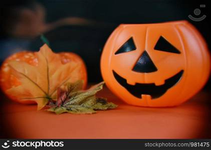 halloween background decorated holidays festive concept / jack o lantern dry leaves autumn pumpkin halloween decorations on orange background for party accessories object