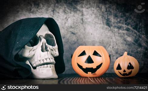 halloween background decorated holidays festive concept / jack o lantern pumpkin halloween decorations with skull on dark background for party accessories object