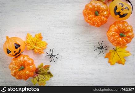 halloween background with dry leaves autumn on wooden decorated holidays festive concept / jack o lantern pumpkin halloween decorations for party accessories object , top view flat lay