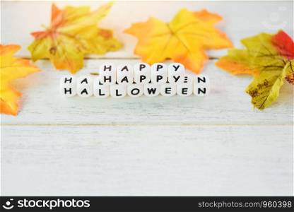 Halloween background with word blocks happy halloween decorations and leaves autumn on white wooden table holiday concept , top view copy space