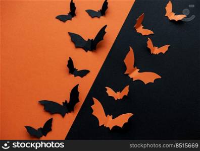 halloween  concept - black and orange paper bats flying over black and orange background