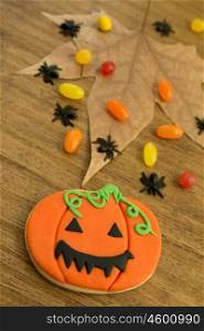 Halloween cookie and candies on a wooden background