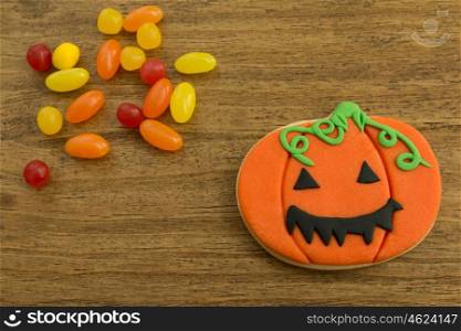 Halloween cookie and candies on a wooden background