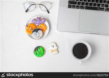 Halloween Cookies, hot coffee and computer laptop on white background. Happy Halloween, online shopping, Hello October, fall autumn, Festive, party and holiday concept