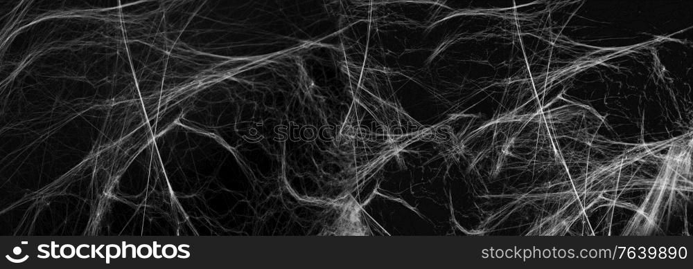 halloween, decoration and horror concept - artificial spider web over black background. halloween decoration of spider web over black