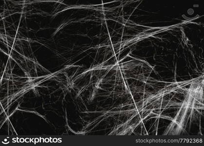 halloween, decoration and horror concept - artificial spider web over black background. halloween decoration of spider web over black