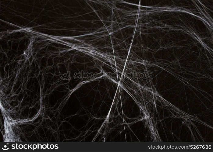 halloween, decoration and horror concept - ecoration of artificial spider web over black background. halloween decoration of spider web over black
