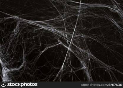 halloween, decoration and horror concept - ecoration of artificial spider web over black background. halloween decoration of spider web over black