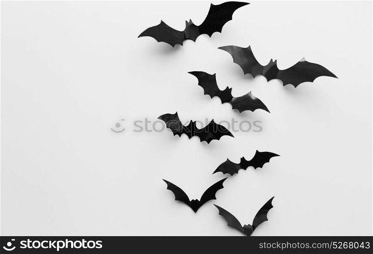 halloween, decoration and scary concept - black bats flying over white background. halloween decoration of bats over white background