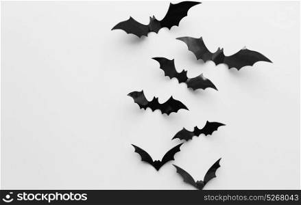 halloween, decoration and scary concept - black bats flying over white background. halloween decoration of bats over white background