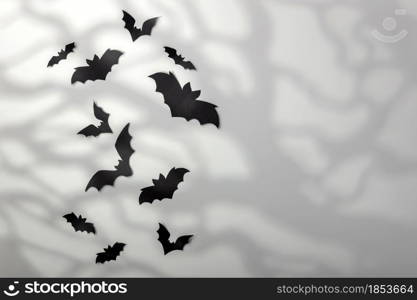 Halloween decoration concept - black paper bats and scary trees shadows background, copy space