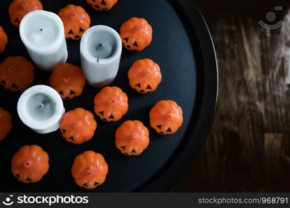 Halloween decoration group of orange pumpkin and white candle on the black table background
