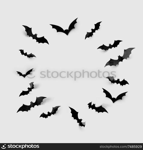 halloween decorations concept - black paper bats in circle on grey background. black halloween bats in circle