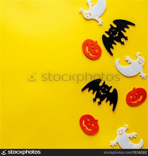 Halloween decorations on yellow background - overhead view flat lay copyspace. Halloween decorations on yellow background, flat lay