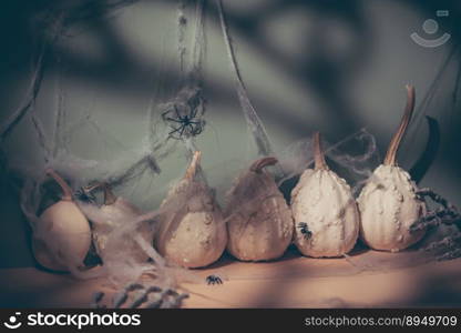 Halloween decorations with pumpkins, bone hands, web and spiders. Halloween atmosfer with shadows. Holiday background. Halloween decorations with pumpkins
