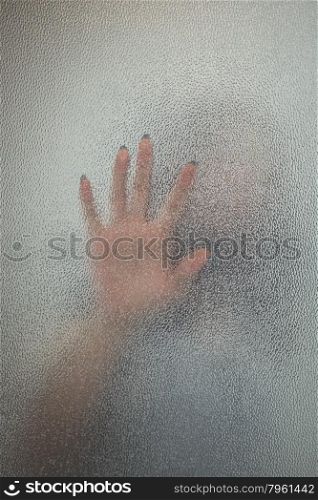 Halloween female hand behind transparent glass background as silhouette