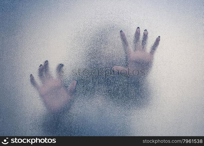 Halloween female hand behind transparent glass background as silhouette