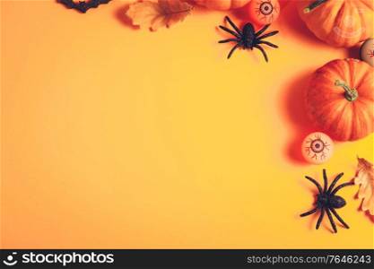 Halloween flat lay scene on orange background with copy space, retro toned. Halloween scene on orange background