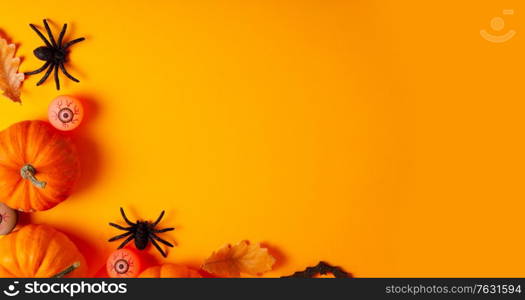 Halloween flat lay scene on orange background with copy space,web banner format. Halloween scene on orange background