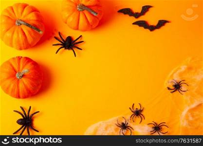 Halloween flat lay top view frame on bright orange background with copy space. Halloween scene on orange background