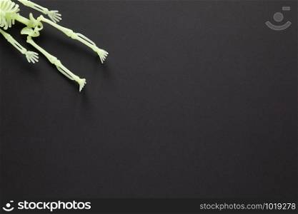 Halloween holiday flat lay. White fluorescent skeleton on black background with copy space. Minimal style. Horizontal. Trick-or-treat concept.