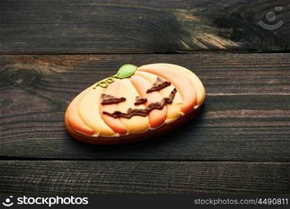 Halloween homemade gingerbread cookie over wooden background