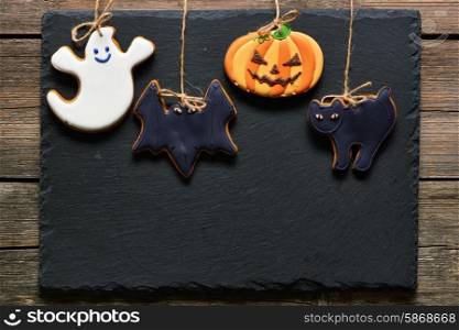 Halloween homemade gingerbread cookies over slate background