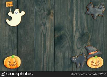 Halloween homemade gingerbread cookies over wooden background