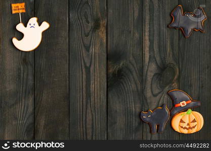 Halloween homemade gingerbread cookies over wooden background