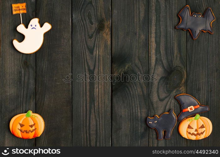 Halloween homemade gingerbread cookies over wooden background