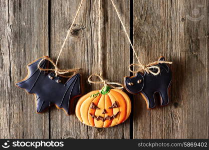 Halloween homemade gingerbread cookies over wooden background