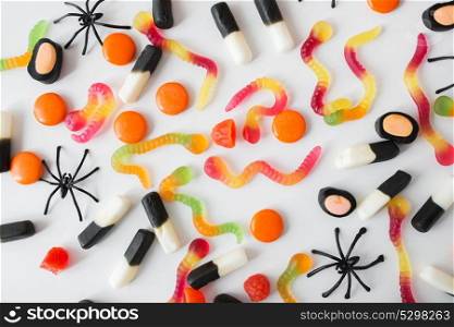 halloween, junk food and confectionery concept concept - multicolored gummy worms and jelly candies over white background. gummy worms and jelly candies for halloween party